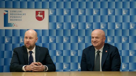 Prezes Zarządu LRFR Rafał Langiewicz oraz Marszałek Województwa Lubelskiego Jarosław Stawiarski siedzący przy stole na tle niebieskiej ścianki prasowej Lubelskiego Regionalnego Funduszu Rozwoju