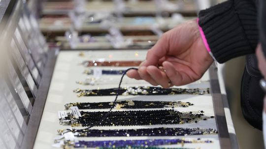 kobieta ogląda bransoletki z naturalnych kamieni