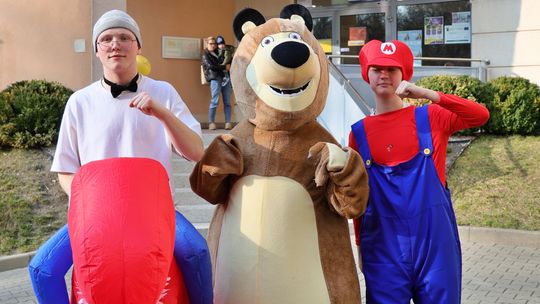 Uczniowie w przebraniach – dinozaura, misia i Mario – podczas wydarzenia w Szkole Podstawowej nr 21 im. Królowej Jadwigi w Lublinie