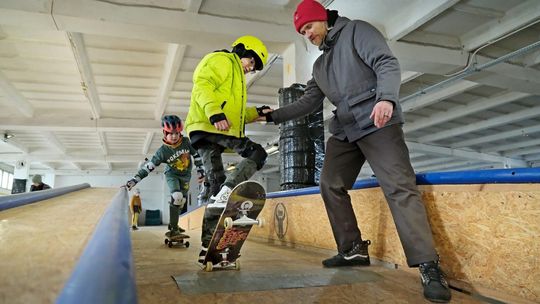 Ferie zimowe w Lublinie – dzieci uczą się jazdy na deskorolce pod okiem instruktora w skateparku