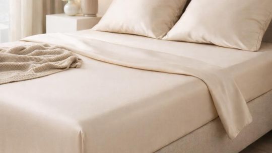 Jasna sypialnia z dopasowanym prześcieradłem na łóżku