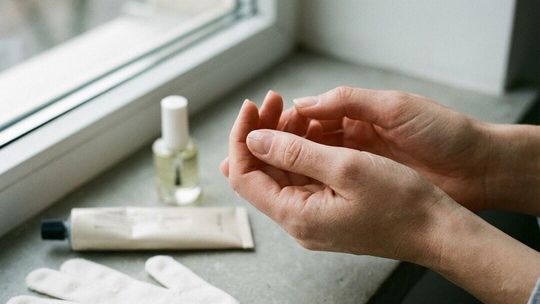 Zbliżenie na osłabiony paznokieć i codzienne akcesoria pielęgnacyjne używane przy łamliwej płytce.