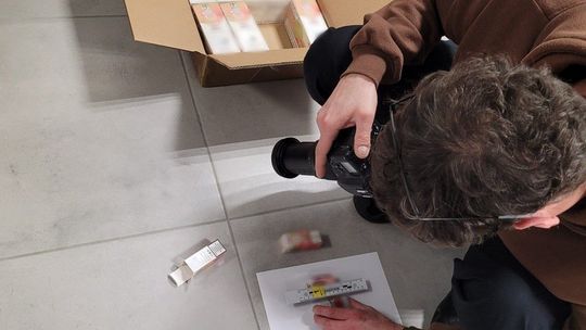 Funkcjonariusz lubelskiej Służby Celno-Skarbowej prezentuje kartony z zabezpieczonymi płynami do papierosów elektronicznych bez polskich znaków akcyzy. Towar został ujawniony podczas kontroli samochodu dostawczego na terenie województwa lubelskiego.