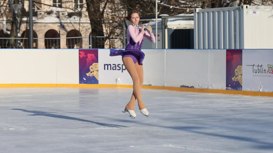 Dziewczynka wykonująca piruet na lodowisku