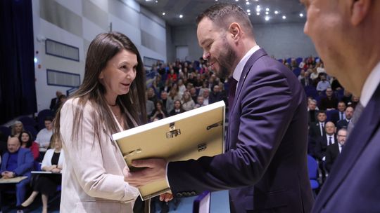 urzędniczka odbiera medal od wojewody