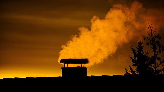 Miasto dopłaci do wymiany pieców. Lublin wzmacnia walkę o czyste powietrze Dym z komina nad domem o zmierzchu – smog i zanieczyszczenie powietrza