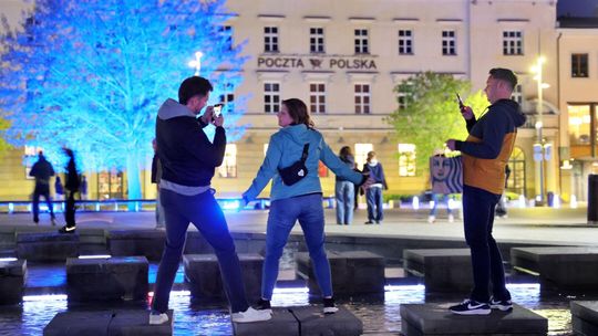 Trójka ludzi pozująca do zdjęcia przy fontannie multimedialnej w Lublinie