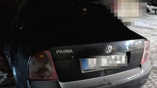 Volkswagen Passat po zdarzeniu drogowym – interwencja policji na ośnieżonym parkingu nocą.