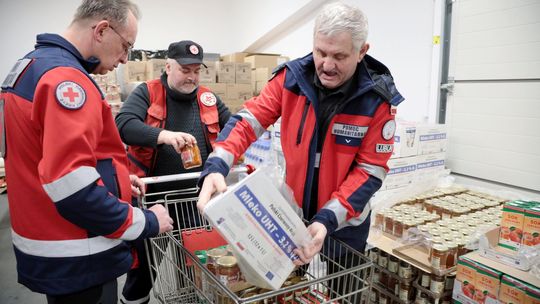 Wydawanie paczek żywnościowych dla potrzebujących przez wolontariuszy PCK