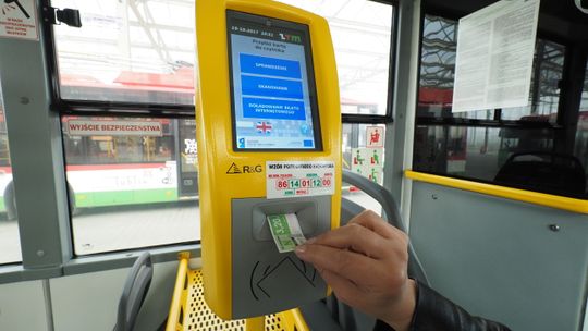Pasażer kasuje bilet w pojeździe komunikacji miejskiej