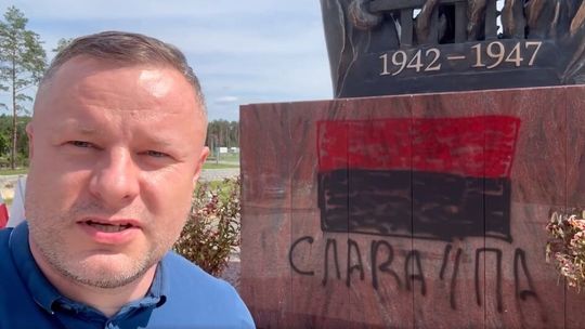 Zdewastowany pomnik ofiar ludobójstwa na Wołyniu. Czerwono-czarna flaga i napis