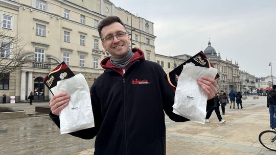 Dziennikarz Dziennika Wschodniego z torebkami wypełnionymi pączkami