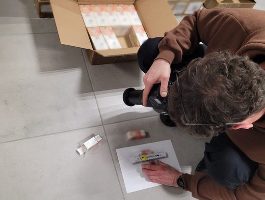 Funkcjonariusz lubelskiej Służby Celno-Skarbowej prezentuje kartony z zabezpieczonymi płynami do papierosów elektronicznych bez polskich znaków akcyzy. Towar został ujawniony podczas kontroli samochodu dostawczego na terenie województwa lubelskiego.