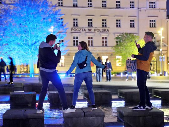 Trójka ludzi pozująca do zdjęcia przy fontannie multimedialnej w Lublinie
