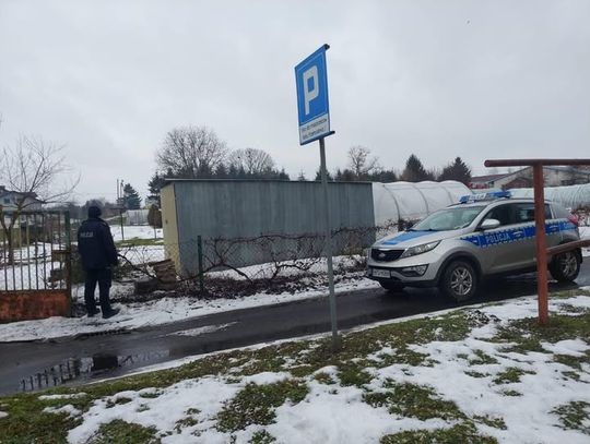 Dzielnicowy z Posterunku Policji w Werbkowicach prowadzi kobietę, która ukryła się w garażu po spowodowaniu kolizji swojego samochodu w stanie nietrzeźwości.