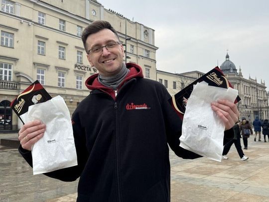 Dziennikarz Dziennika Wschodniego z torebkami wypełnionymi pączkami