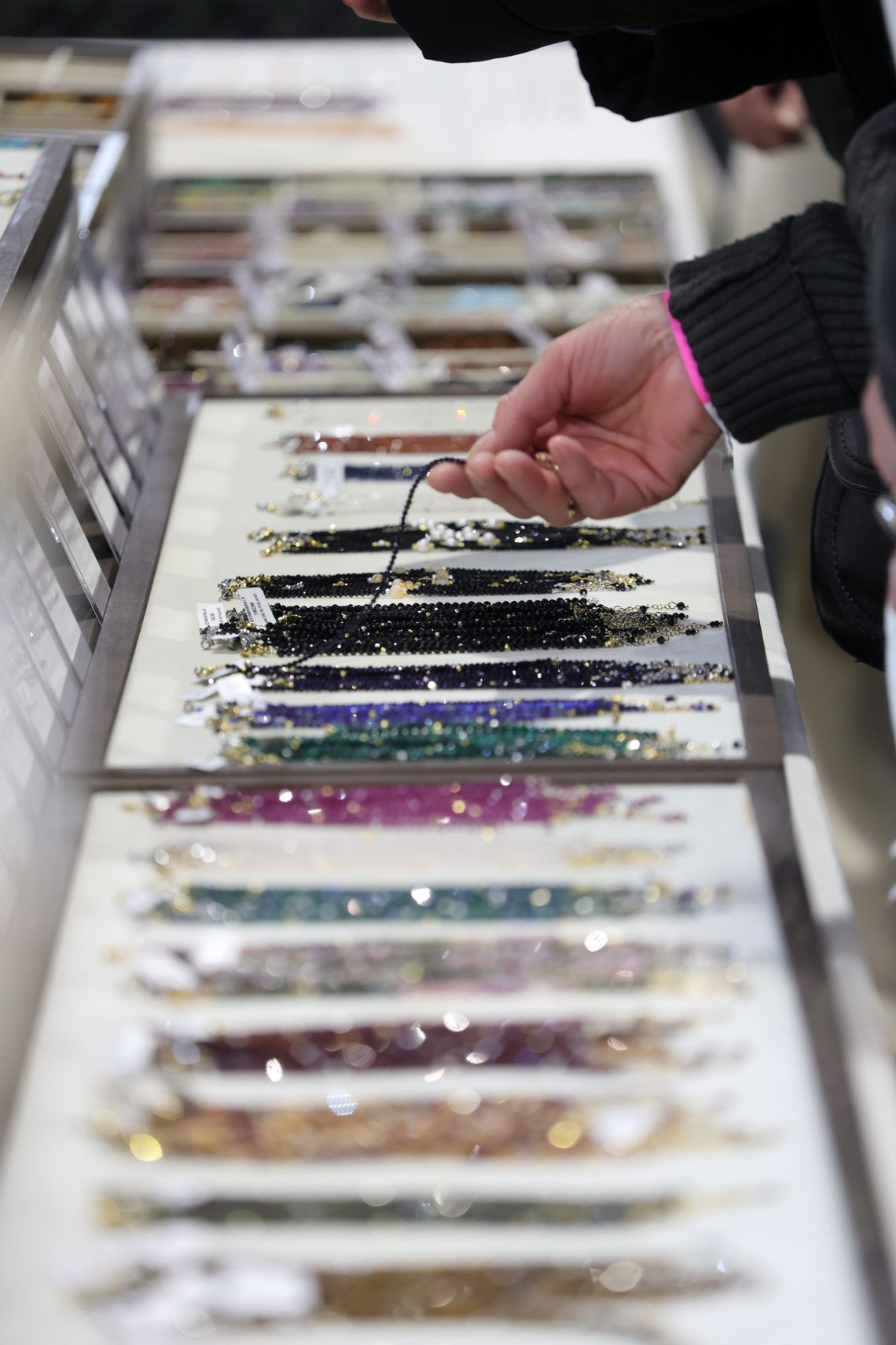 kobieta ogląda bransoletki z naturalnych kamieni