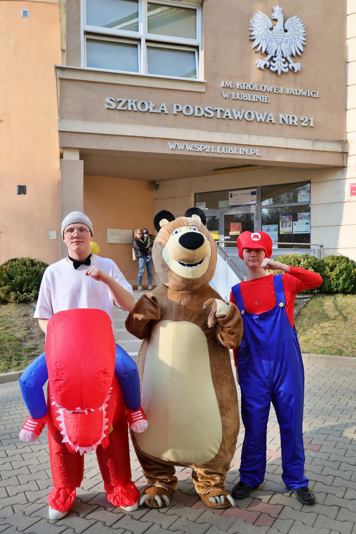 Uczniowie w przebraniach – dinozaura, misia i Mario – podczas wydarzenia w Szkole Podstawowej nr 21 im. Królowej Jadwigi w Lublinie