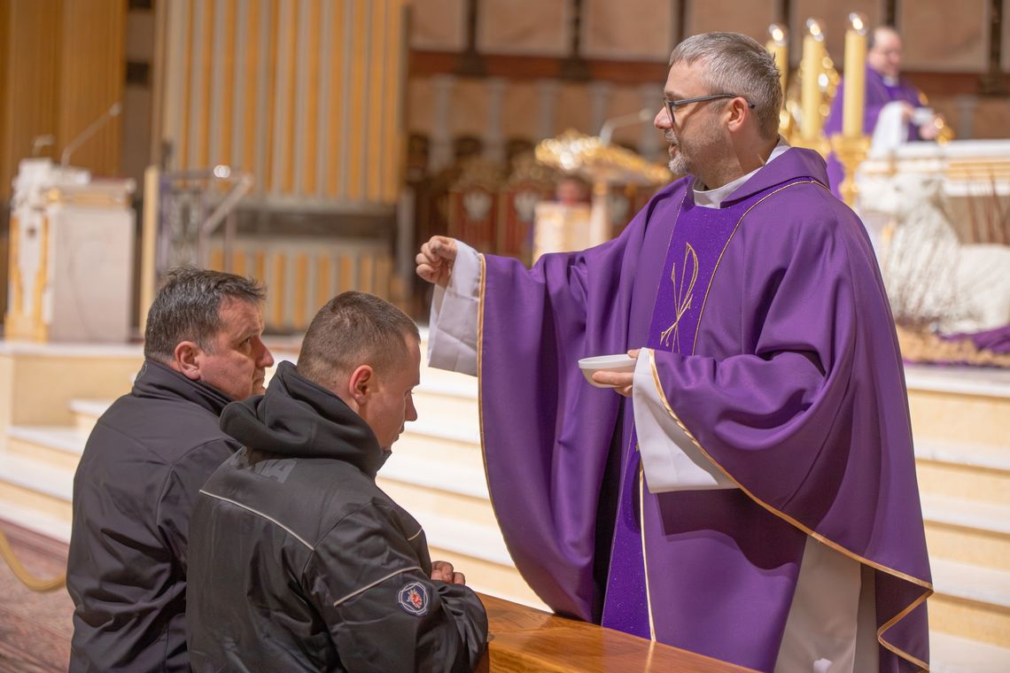 ksiądz posypuje głowy wiernych popiołem
