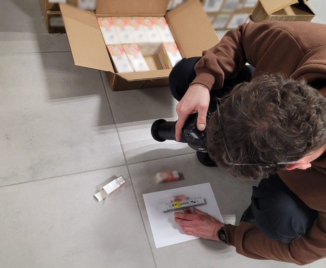 Funkcjonariusz lubelskiej Służby Celno-Skarbowej prezentuje kartony z zabezpieczonymi płynami do papierosów elektronicznych bez polskich znaków akcyzy. Towar został ujawniony podczas kontroli samochodu dostawczego na terenie województwa lubelskiego.
