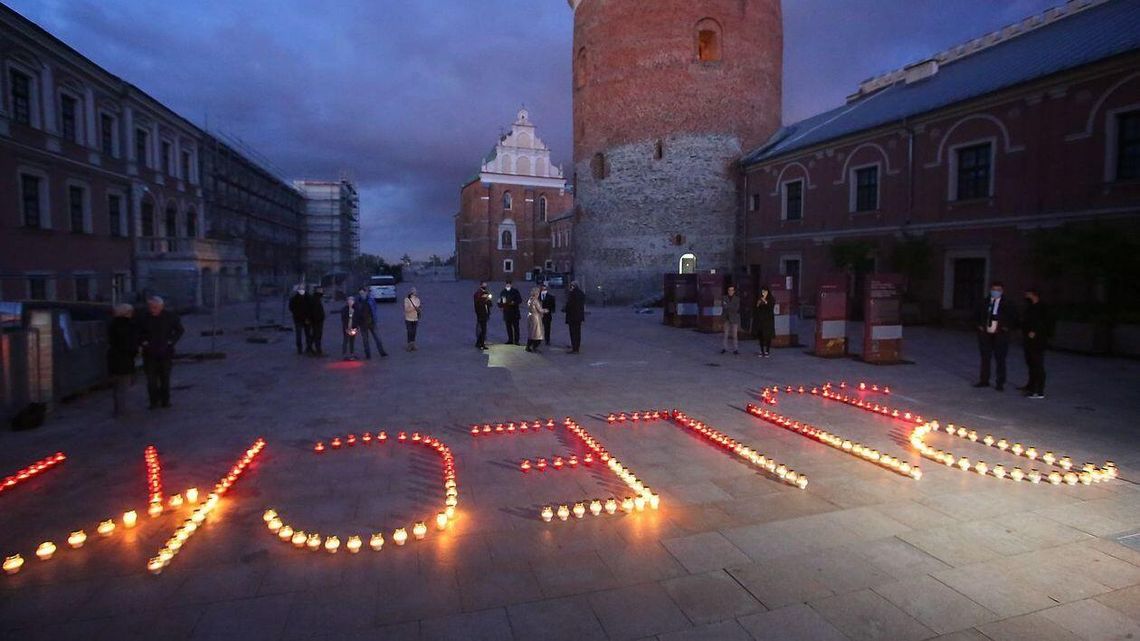 Napis z biało-czerwonych zniczy na dziedzińcu Zamku Lubelskiego