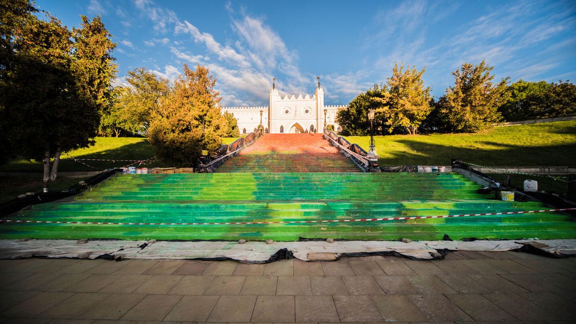 Open City 2022. Na schodach łąka, na gzymsie wielkie niemowlę