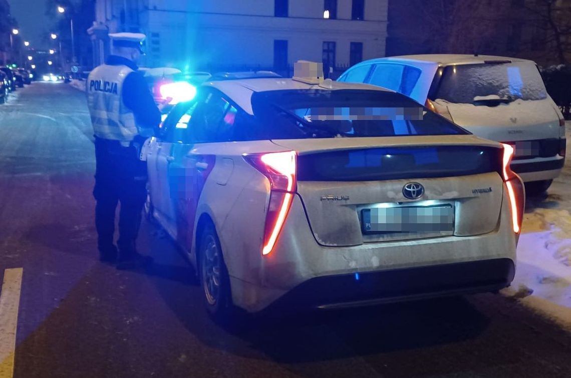 Policyjna kontrola drogowa nocą – radiowóz z włączonymi sygnałami na ulicy