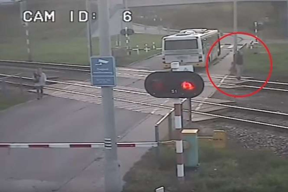 Tył autobusu na torach. Kierowca próbuje machaniem zatrzymać Pendolino