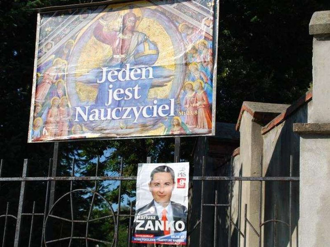 Włodawa: Plakat kandydata na ogrodzeniu kościoła Włodawa: Plakat kandydata na ogrodzeniu kościoła