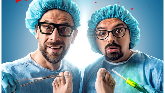 Kabaretowy plakat promocyjny – dwaj mężczyźni przebrani za chirurgów z narzędziami medycznymi, zapowiedź występu kabaretowego w Lublinie.