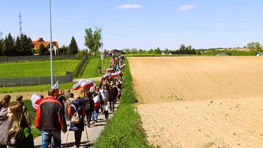 Marsz z biało-czerwonymi flagami na wiejskiej drodze w woj. lubelskim – uczestnicy patriotycznego przemarszu wśród pól i zabudowań.