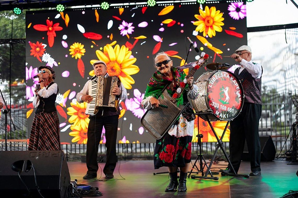 Ulica Gra! XXVII Festiwal Kapel Podwórkowych w Łęcznej Zespół ludowy podczas występu na scenie – muzycy w tradycyjnych strojach grają koncert z akordeonem i bębnem.