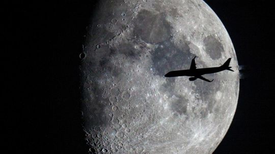 Samolot rejsowy na tle Księżyca