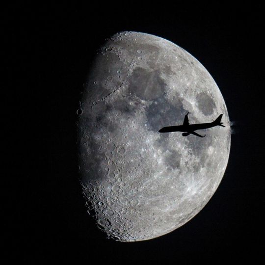 Samolot rejsowy na tle Księżyca