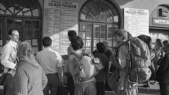 Pasażerowie przy tablicy rozkładu jazdy pociągów PKP