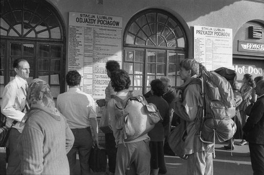 Pasażerowie przy tablicy rozkładu jazdy pociągów PKP