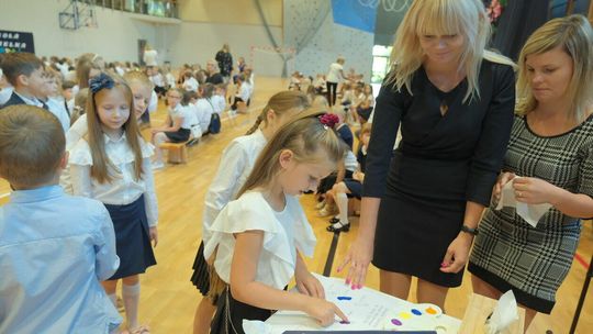 Dzieci składają odciski palców w księdze