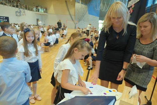 Dzieci składają odciski palców w księdze